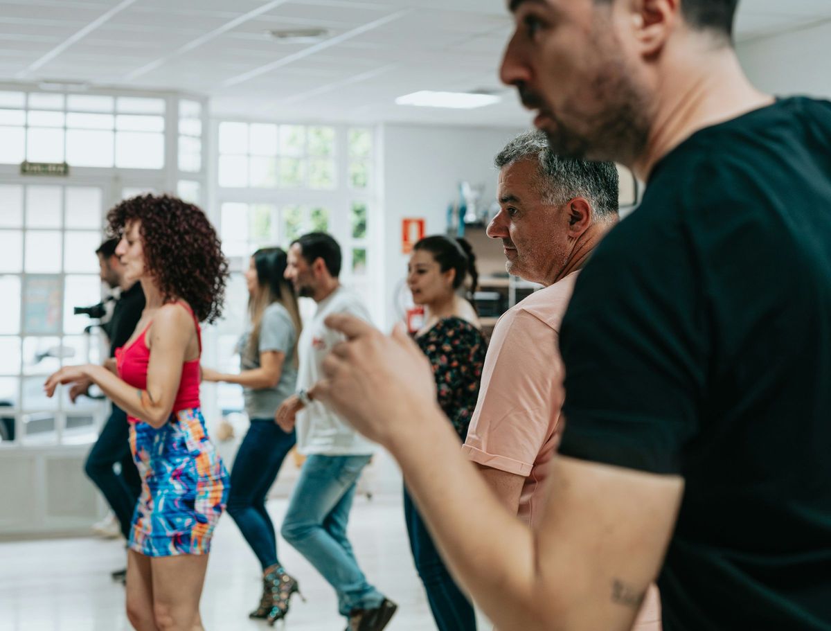 Students dancing together in a bright studio class