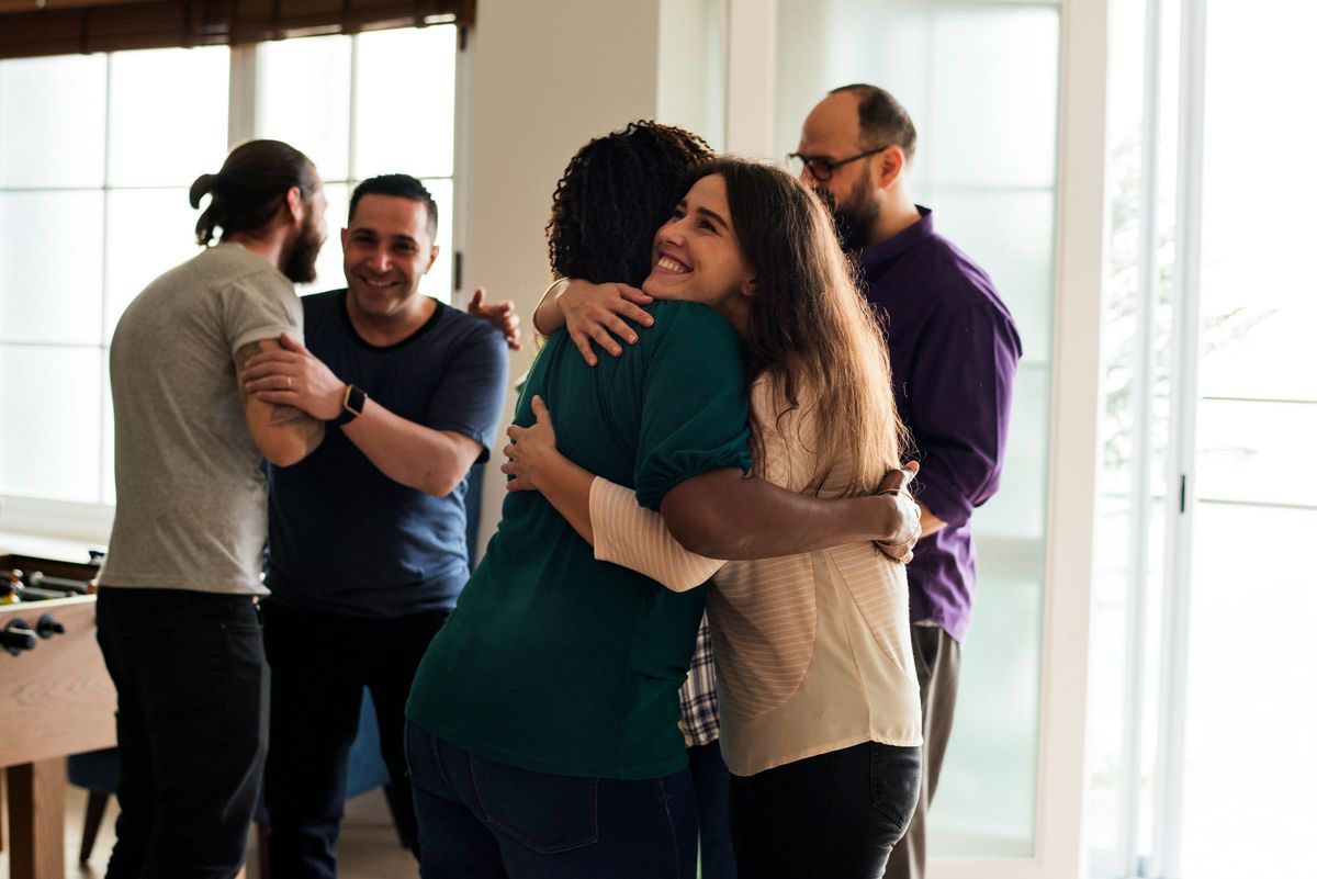 Friends greeting each other with a warm hug