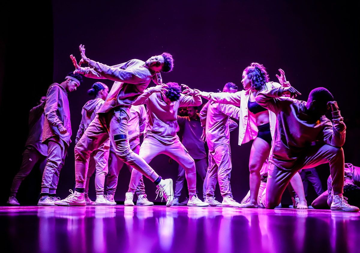 A dance group performing together on stage