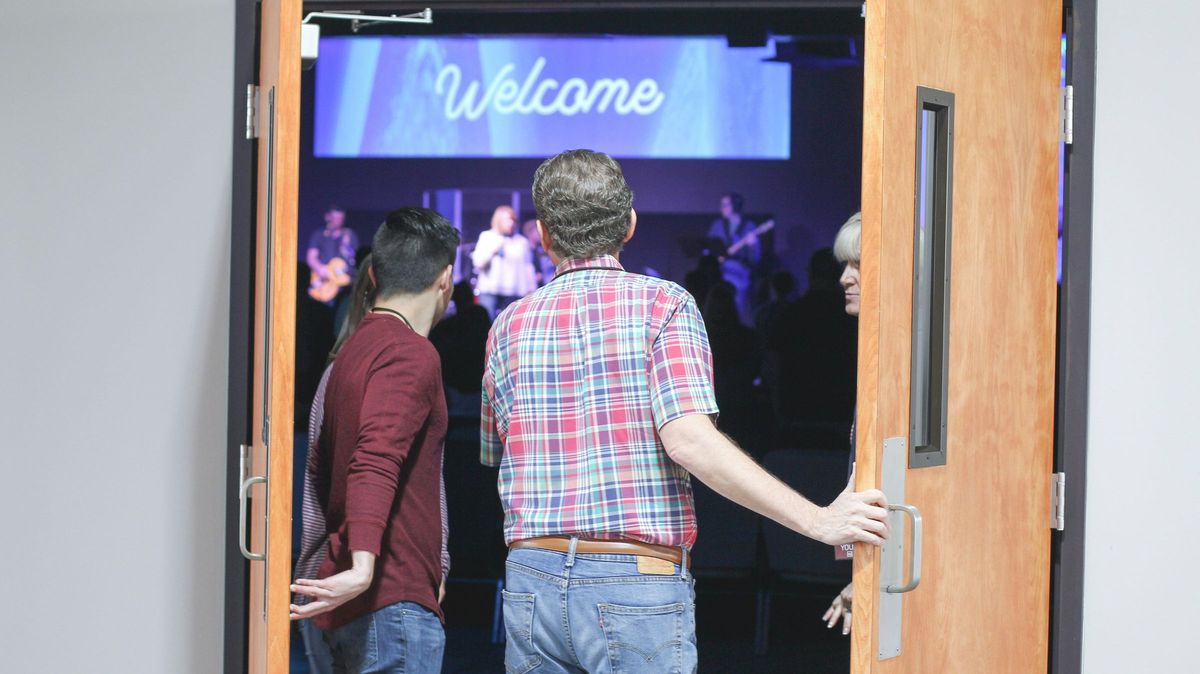People walking through an open double door into a welcoming event