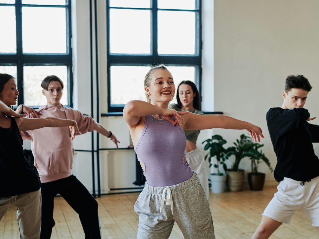 A dance class caught mid turn in a mirrored studio